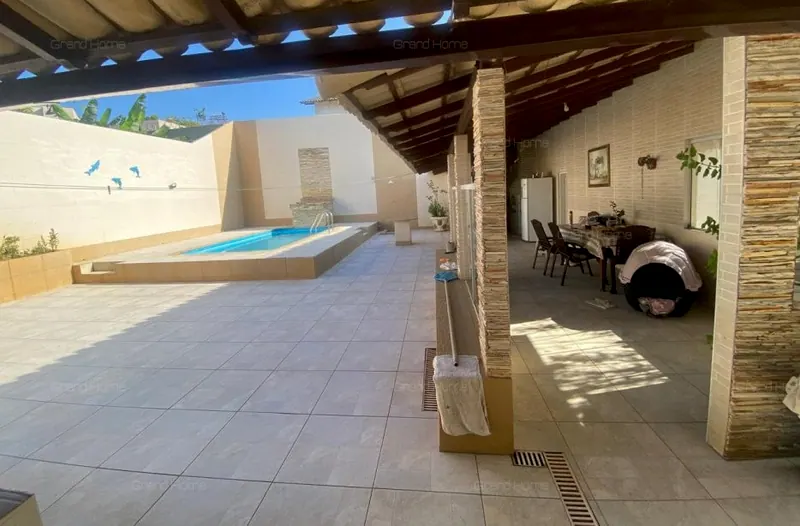 Piscina e varanda coberta com mesa de jantar