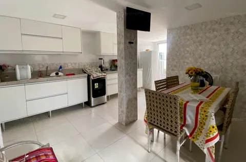 Cozinha com armários brancos e mesa