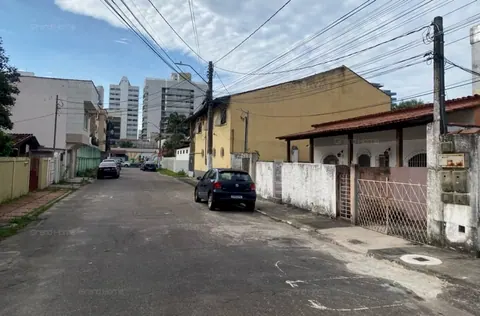 Rua da casa, com prédios ao fundo