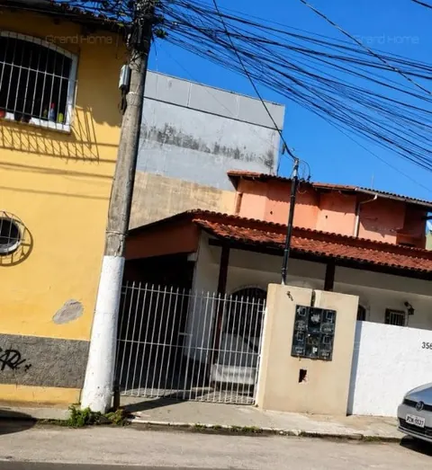 Frente da casa com portão gradeado e caixa de medidores