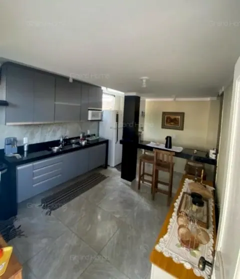 Cozinha com armários e bancada de pedra escura