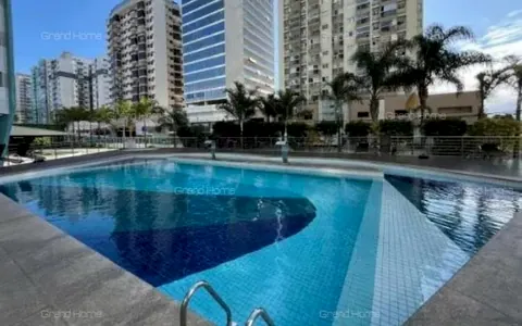Piscina do condomínio cercada de palmeiras