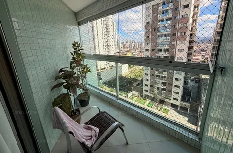 Varanda envidraçada com tela de proteção e vista para os prédios vizinhos