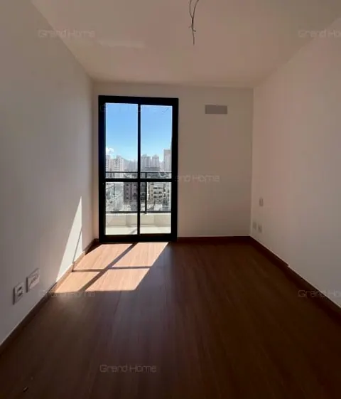 Cômodo vazio com piso amadeirado e porta de vidro para a varanda